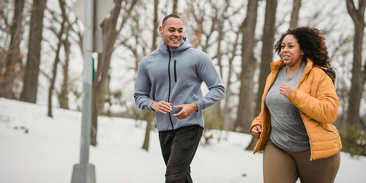 Two people going on a brisk walk in a snowy forest