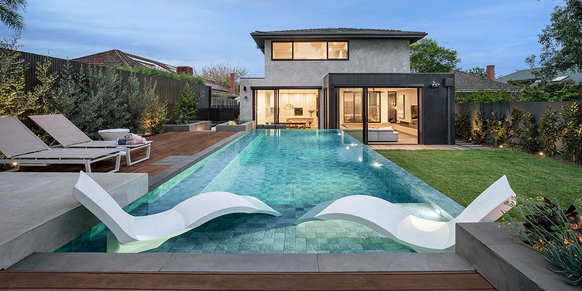 Small backyard with a pool and lounge chairs