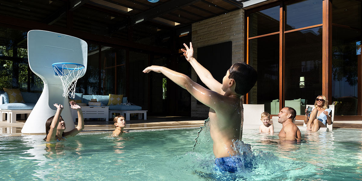 Family playing basketball in the pool