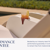 A cold drink with a lemon slice sits on the Signature Chaise Armrest Console by Ledge Lounger, resting on a white outdoor lounge chair by the pool. Enjoy our Performance Guarantee and a 15-year warranty against material defects.