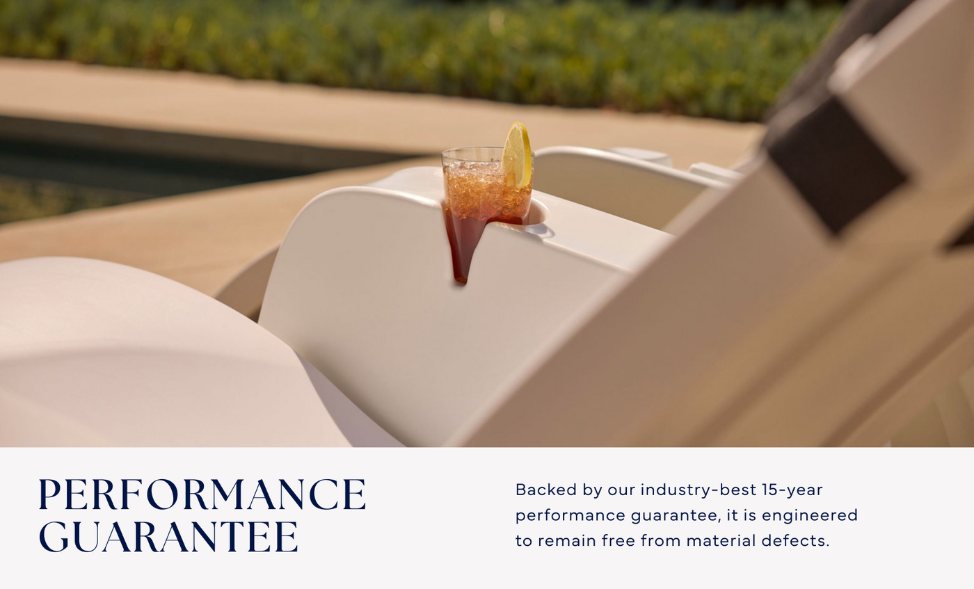 A cold drink with a lemon slice sits on the Signature Chaise Armrest Console by Ledge Lounger, resting on a white outdoor lounge chair by the pool. Enjoy our Performance Guarantee and a 15-year warranty against material defects.