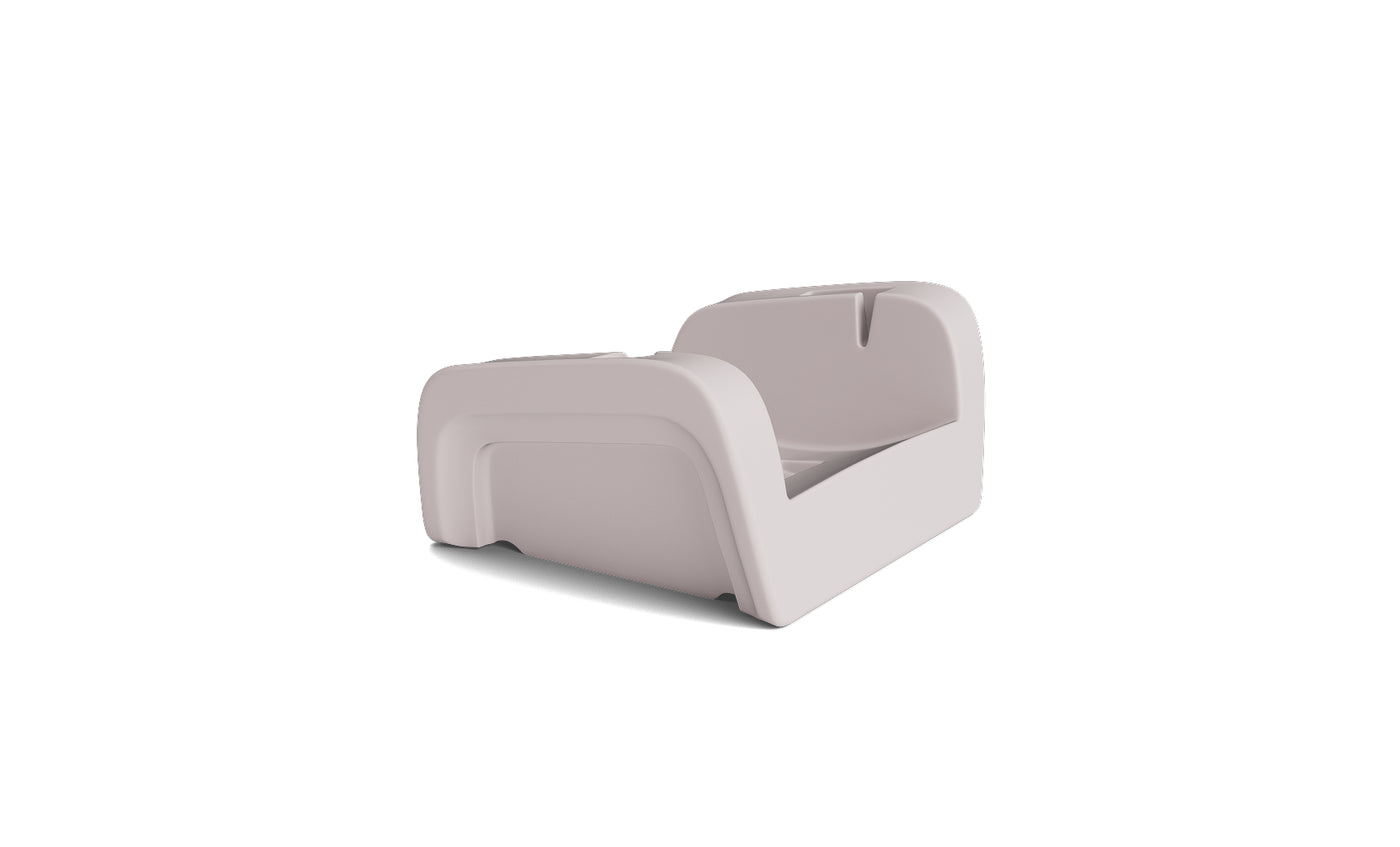 The Ledge Lounger Signature Chaise Armrest Console is a modern, light gray plastic toddler bed with raised safety sides—ideal for relaxing or upright reading—displayed against a plain white background.