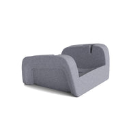 The Signature Chaise Armrest Console by Ledge Lounger features a contoured design with raised sides and a backless structure, offering comfort for reading or relaxing; shown on a white background.