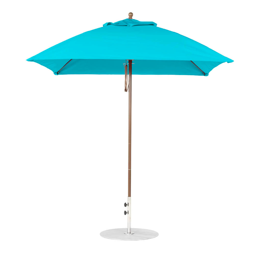 A fully open blue Ledge Lounger Essential Fiberglass Umbrella, with a 7.5 square pulley design, wooden pole, and white metal base, crafted from marine-grade fabrics featuring a classic finial on top, stands against a plain white background.