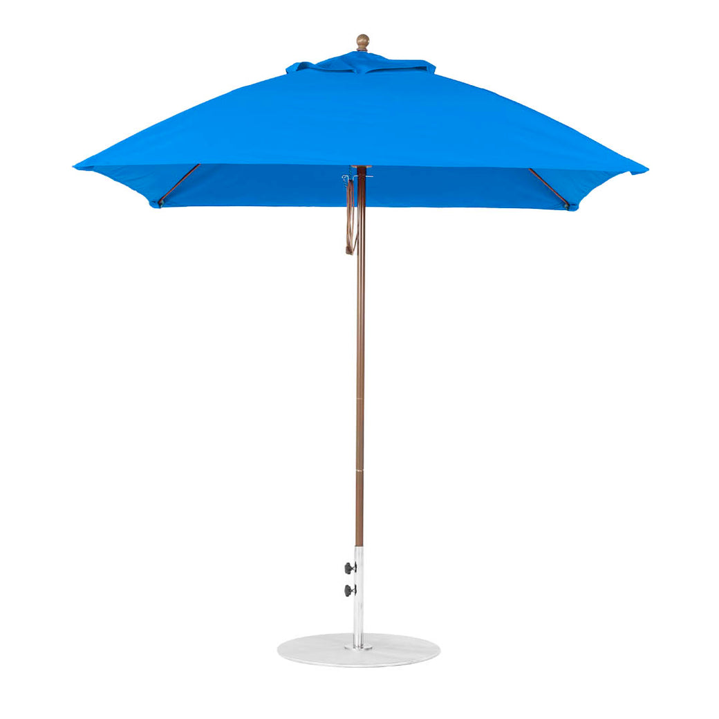The Essential Fiberglass Umbrella - 7.5 Square Pulley by Ledge Lounger, featuring a bright blue canopy and sturdy wooden base, stands open against a plain white background.