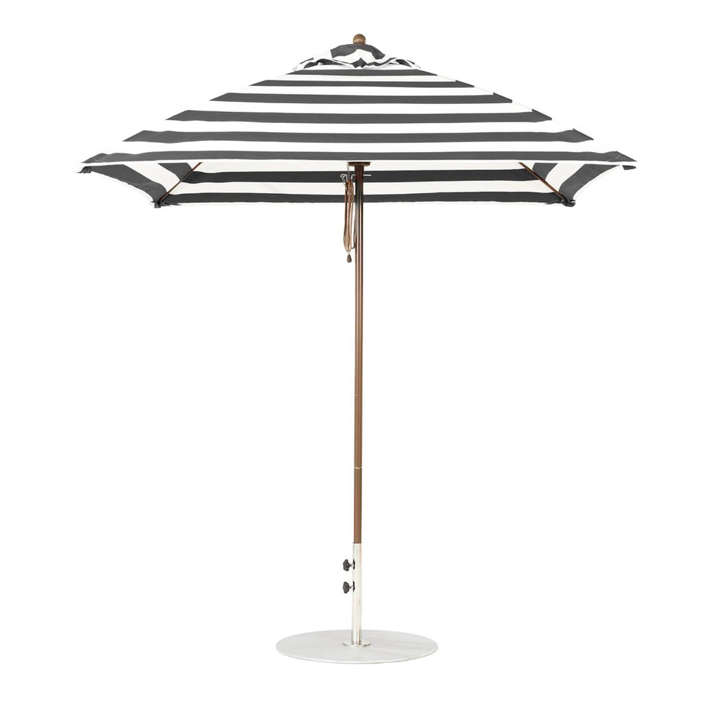 The Ledge Lounger Essential Fiberglass Umbrella in black and white stripes, with marine-grade fabric and a wooden pole, boasts a 7.5 square design with a round white base, showcasing its classic pattern when open.