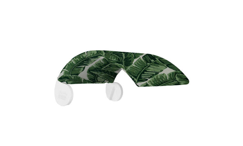 A shelf sporting a banana leaf pattern with curved white brackets is designed to bring tropical flair to your space, akin to an in-pool tanning ledge or shade from the Signature Chair by Ledge Lounger. Its surface showcases a vibrant green leaf design.