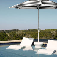 The Ledge Lounger Signature Chaise and Side Table with Umbrella In-Pool Set offers a stylish spot in shallow water, featuring a black-and-white umbrella with scenic views—ideal for relaxing poolside.