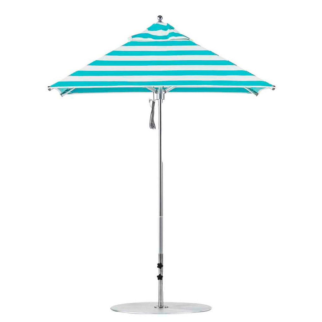 The Premier Aluminum Umbrella by Ledge Lounger features turquoise and white marine-grade fabric in a square design with a central silver pole, round base, and wind-resistant canopy that forms a conical shape. It is complemented by a small finial at the top.