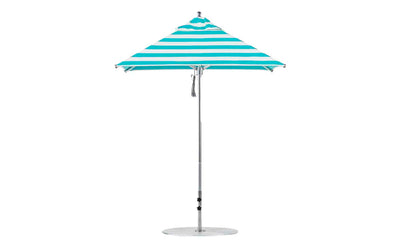The Premier Aluminum Umbrella by Ledge Lounger features turquoise and white marine-grade fabric in a square design with a central silver pole, round base, and wind-resistant canopy that forms a conical shape. It is complemented by a small finial at the top.