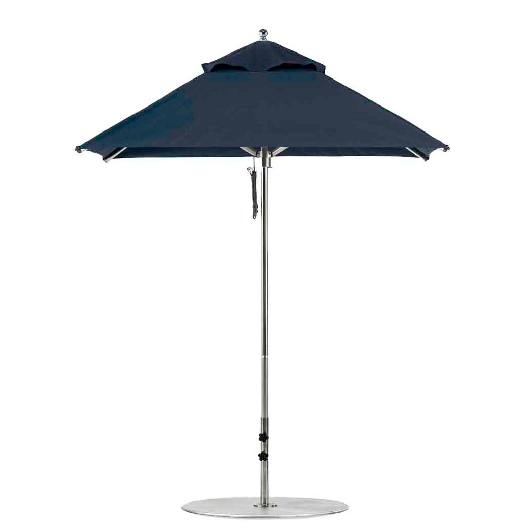 The Premier Aluminum Umbrella - 6.5 Square Pulley by Ledge Lounger is a sleek, dark blue design featuring a wind-resistant metal stand and circular base. Displayed against a white background, its wide canopy is crafted from marine-grade fabrics with a simple, modern aesthetic.