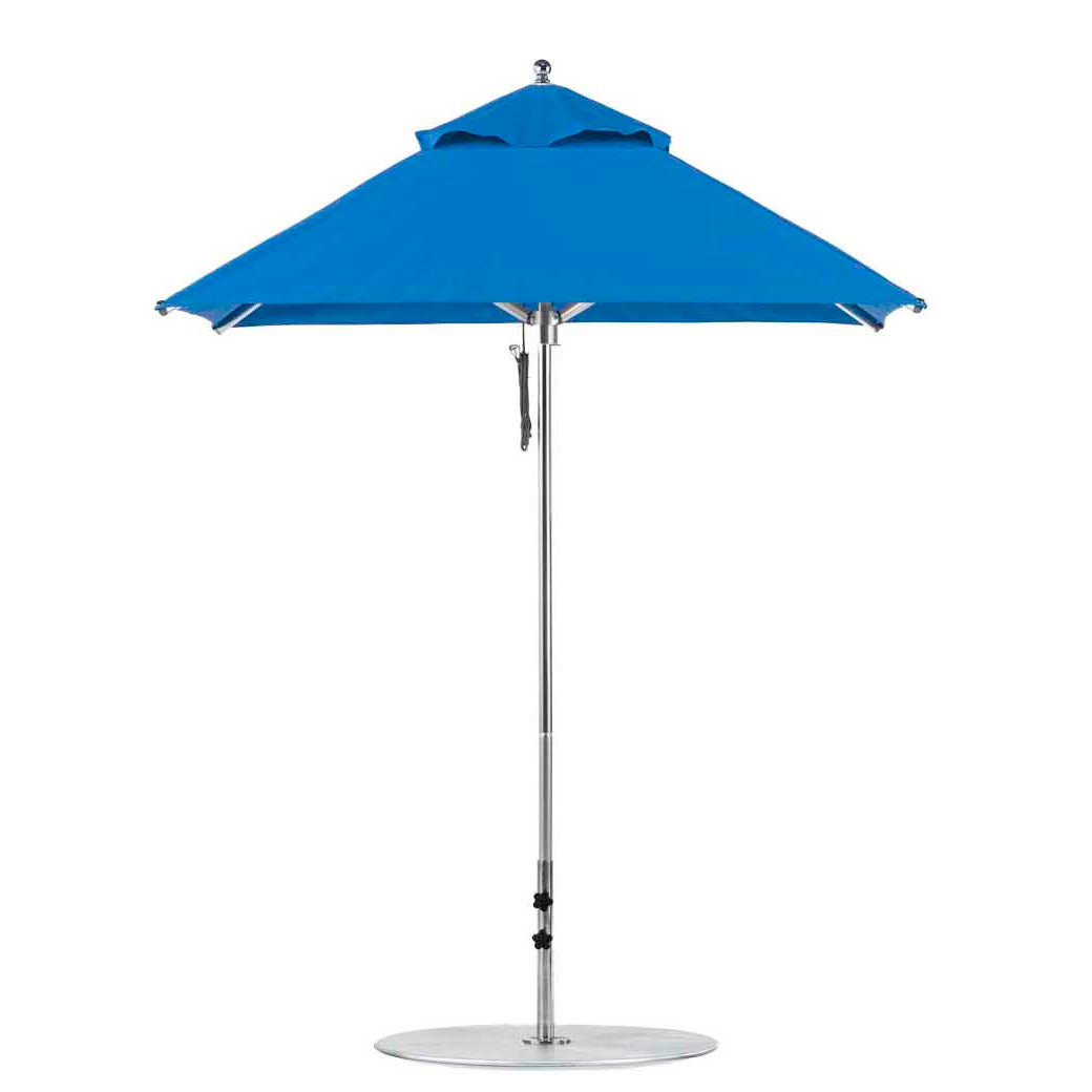 The Ledge Lounger Premier Aluminum Umbrella features a wind-resistant design with marine-grade fabrics, an aluminum pole, and a sturdy round base. The 6.5 square pulley model is fully opened for beach use.