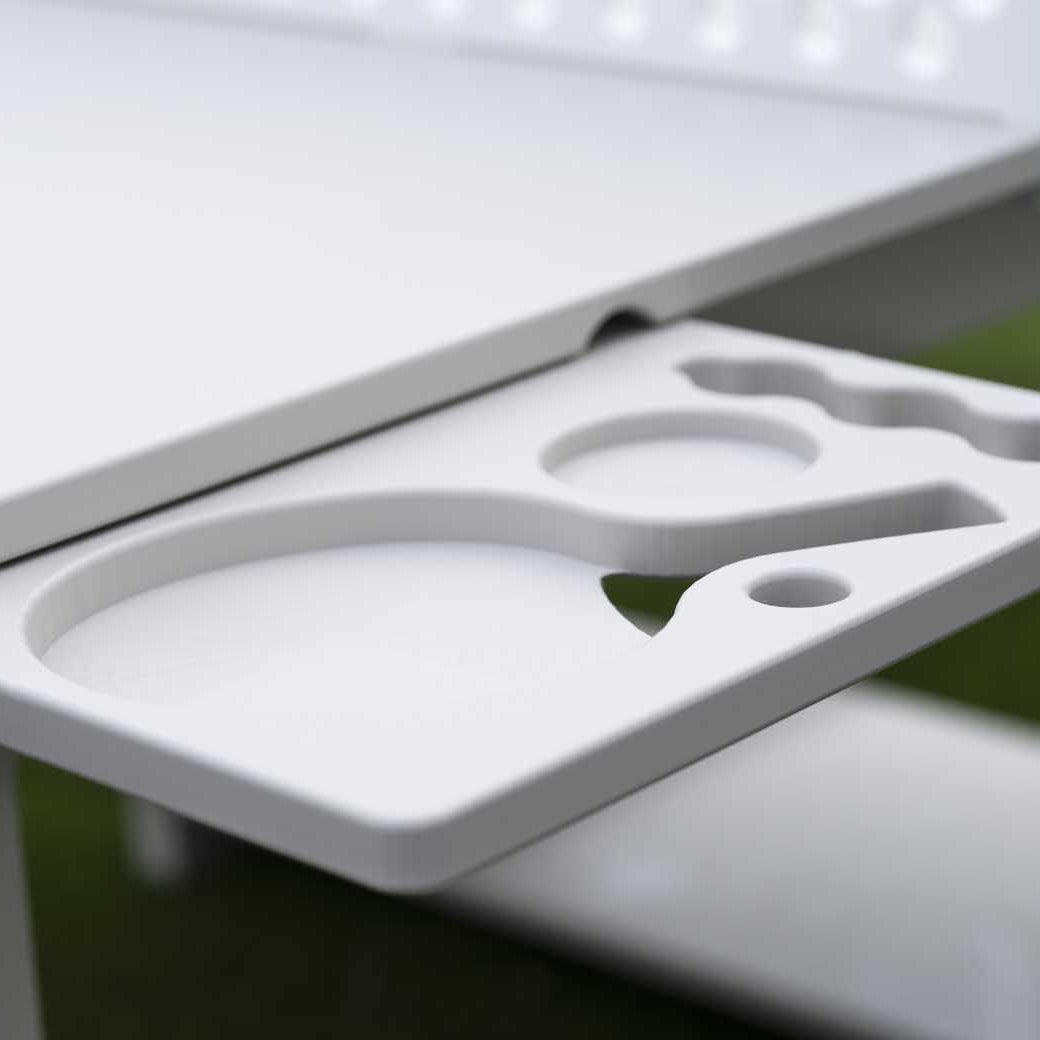A close-up shows the Ledge Lounger Table Tennis Set holder attached to a table, featuring slots for two paddles and several balls. The grassy, blurred background enhances its outdoor entertainment appeal.