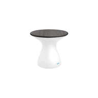 The Autograph Standard Side Table by Ledge Lounger is a modern piece with a sleek design, boasting a glossy white base and round dark wooden seat. Its minimalist hourglass shape perfectly suits outdoor use, blending style and function effortlessly.