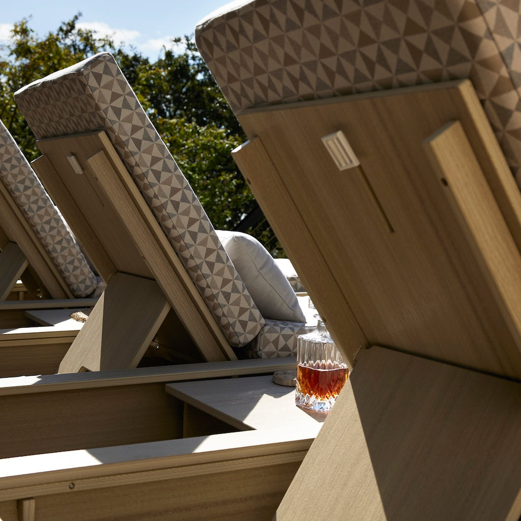 Row of foldable lounge chairs with geometric patterned cushions and wooden frames