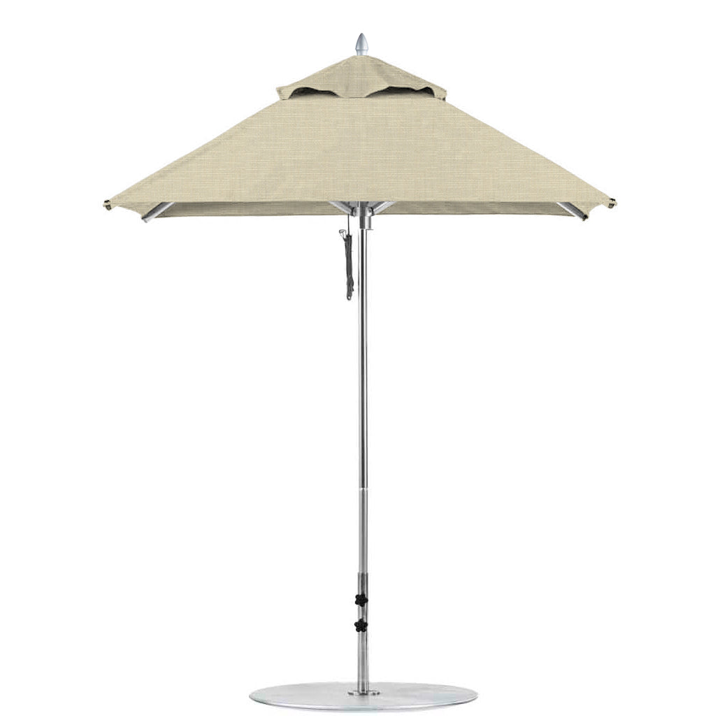 A Ledge Lounger Premier Aluminum Umbrella in beige features a round canopy with a silver pole on a circular base, available as a 6.5 square pulley model in the final sale.
