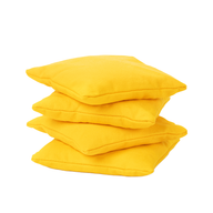 Three vibrant yellow, durable square bean bags from the Ledge Lounger Bean Bags Set of Four are stacked unevenly against a plain white background.