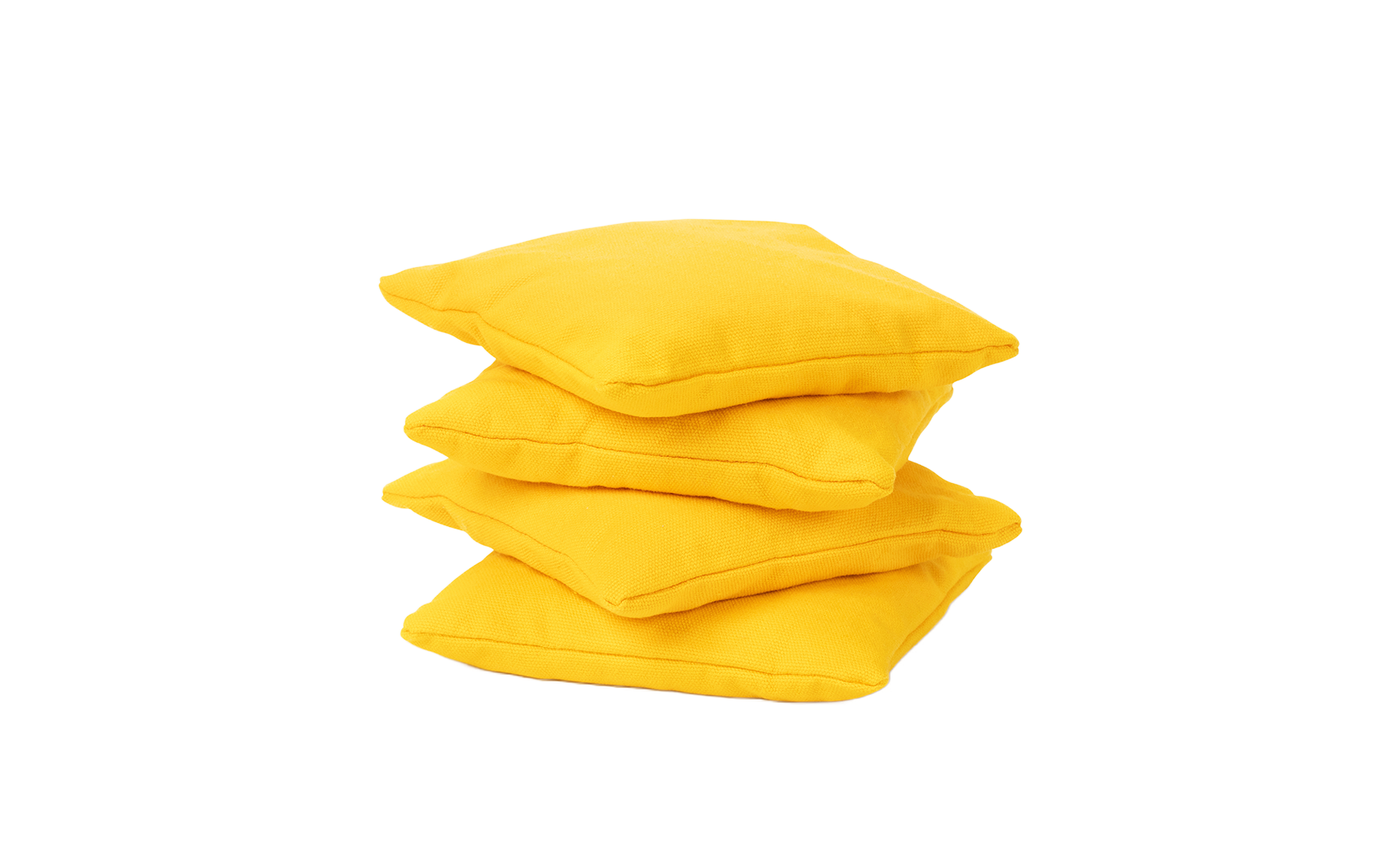 Three vibrant yellow, durable square bean bags from the Ledge Lounger Bean Bags Set of Four are stacked unevenly against a plain white background.