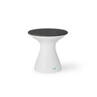 The Autograph Tall Ice Bin Side Table by Ledge Lounger has a modern design with a white, curved pedestal base and a dark round seat. The base tapers in and flares at the top, featuring a small turquoise logo near the bottom.