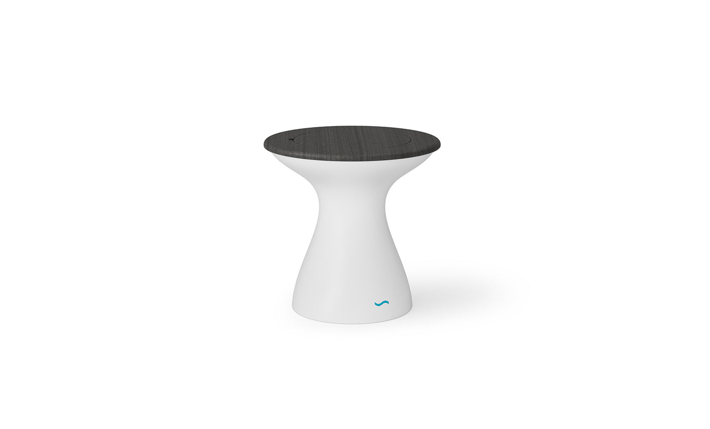 The Autograph Tall Ice Bin Side Table by Ledge Lounger has a modern design with a white, curved pedestal base and a dark round seat. The base tapers in and flares at the top, featuring a small turquoise logo near the bottom.