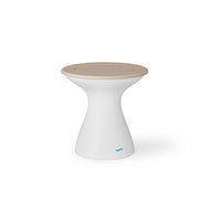 The Autograph Tall Ice Bin Side Table by Ledge Lounger is a modern, hourglass-shaped table featuring a beige circular top. Its sleek design and discreet blue logo make it a chic addition to any patio. Set against a plain white background, it adds style to outdoor settings.