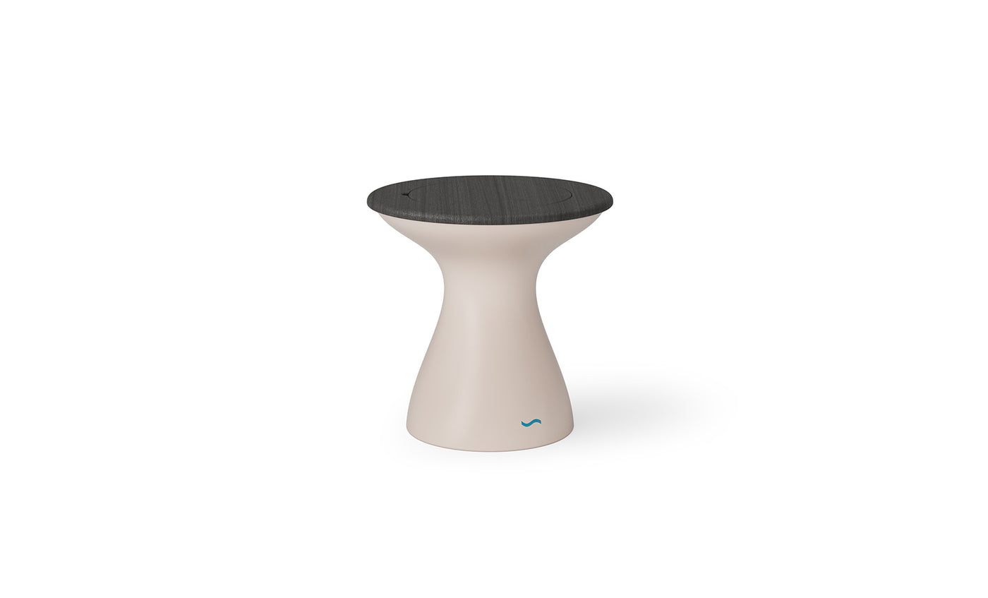 The Autograph Tall Ice Bin Side Table by Ledge Lounger is a modern, hourglass-shaped piece featuring a sleek beige base and dark round top. Its versatility allows it to function as an outdoor stool or minimalist side table, enhancing its contemporary appeal.