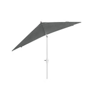 The 8.5 Square Signature 360° Tilt Umbrella by Ledge Lounger, with its gray canopy and white pole, is subtly tilted on a white backdrop. Made from premium materials, it showcases visible adjustment mechanisms for perfect positioning and reveals an angular, streamlined design.
