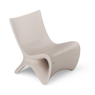 The Autograph Chair by Ledge Lounger is a modern beige lounge chair with a sleek, curved design ideal for outdoor relaxation. Its minimalist, fluid look features smooth contours and a low seat, offering elevated ergonomics for ultimate comfort.