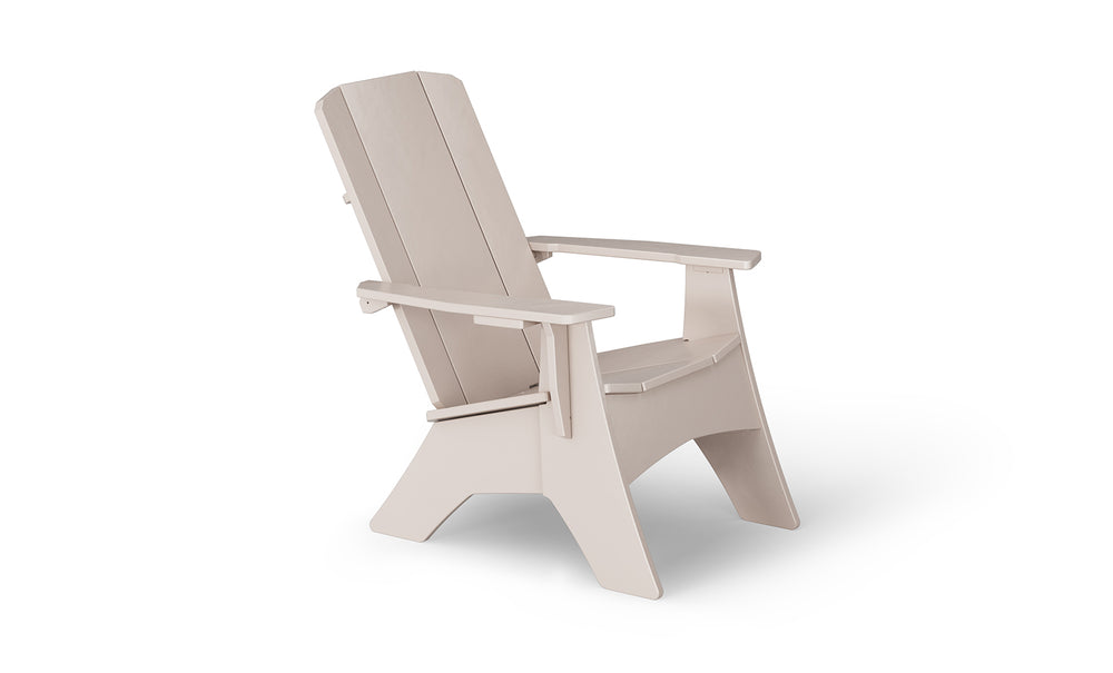The Mainstay Ultimate Adirondack by Ledge Lounger, in beige, is the ideal outdoor lounge furniture. With wide armrests and a slanted backrest, it promises stylish poolside relaxation. Viewed from the side against a white backdrop, it offers both comfort and elegance.