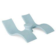 The Outdoor Oasis In-Pool Furniture Bundle by Ledge Lounger is a modern, sculptural double lounge chair in light blue, made of a smooth material. It has wave-like curves and a central circular table between the seats, perfect for sleek indoor or outdoor seating.
