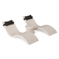 The Ledge Lounger Signature Chaise Headrest Pillow and Side Table In-Pool Set features modern beige double wave-shaped chaise loungers with black headrest pillows and a round table between them, set against a white background.