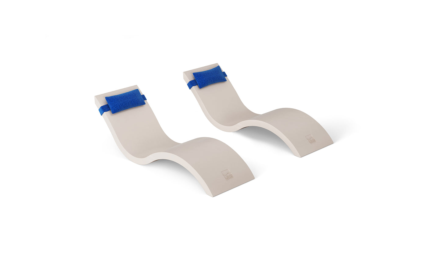 The Outdoor Escape In-Pool Furniture Bundle by Ledge Lounger includes two identical beige curved chaise lounges with a wavy design and blue padded straps as headrest pillows, positioned side by side for an enhanced outdoor setting.