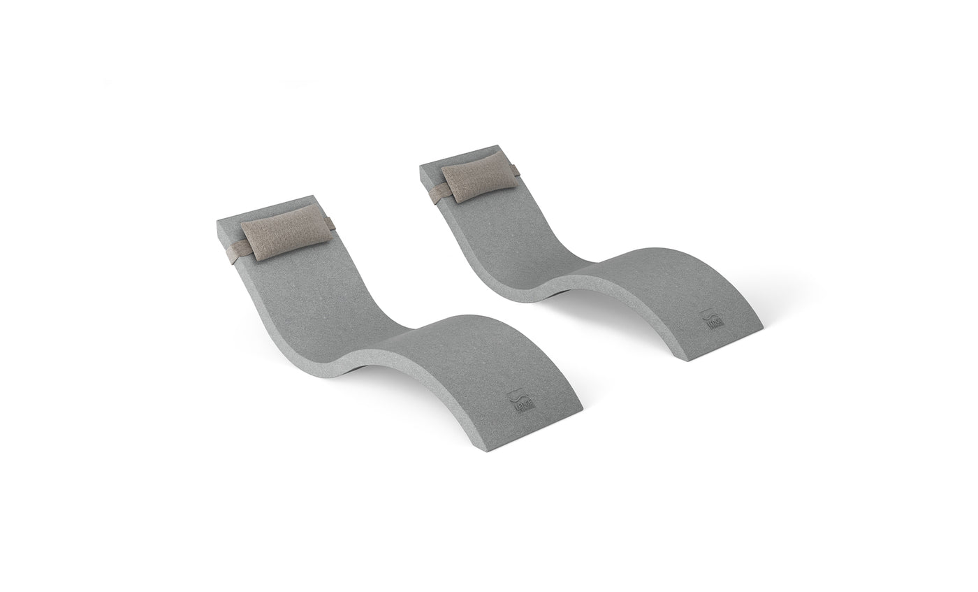 The Outdoor Escape In-Pool Furniture Bundle by Ledge Lounger features two chic, wave-shaped gray reclining loungers with cushioned headrests, set against a white backdrop. Ideal for ultimate comfort, these stylish chaise lounges complement any modern outdoor furniture collection.