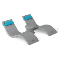 The Outdoor Paradise In-Pool Furniture Bundle by Ledge Lounger is a sleek, gray U-shaped kayak rack with two raised supports and blue padding. It features a central circular indentation for secure kayak holding, mimicking the modern elegance of pool ledge furniture.