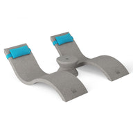 The Ledge Lounger Outdoor Paradise In-Pool Furniture Bundle features a gray ergonomic footrest with two raised arches, blue cushioned straps, and a central cylindrical structure for balance and comfort. Ideal for under-desk use or as a poolside seat for an outdoor workspace vibe.