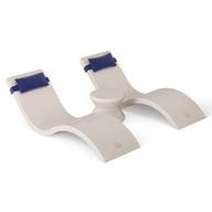 The modern wooden rocking chair in the Ledge Lounger Outdoor Paradise In-Pool Furniture Bundle features a white finish, two curved sections, and a central circular connector. Dark blue cushioned headrests enhance relaxation, making it ideal for your pool ledge oasis.