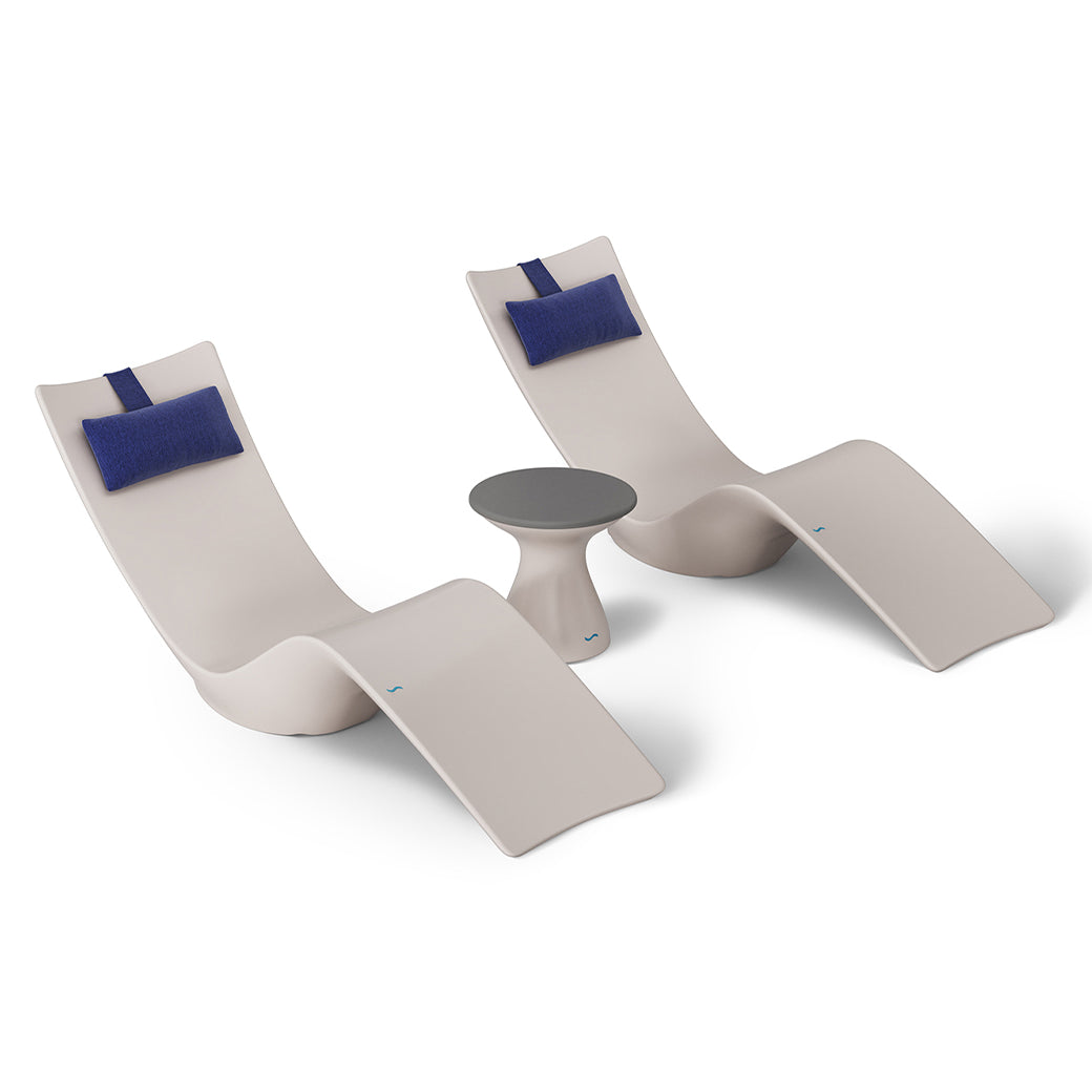 Ledge Loungers Resort Luxury Outdoor Paradise In-Pool Furniture Bundle includes two modern beige lounge chairs with blue headrests and a small round table, all in a minimalist style. This set evokes poolside relaxation and is showcased on a white background.