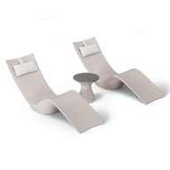 The Ledge Lounger Resort Luxury Outdoor Paradise In-Pool Furniture Bundle includes two sleek beige lounge chairs with curved designs, placed beside a small round side table with a dark gray top. Ideal for poolside relaxation, they each feature white headrest cushions against a plain white backdrop.