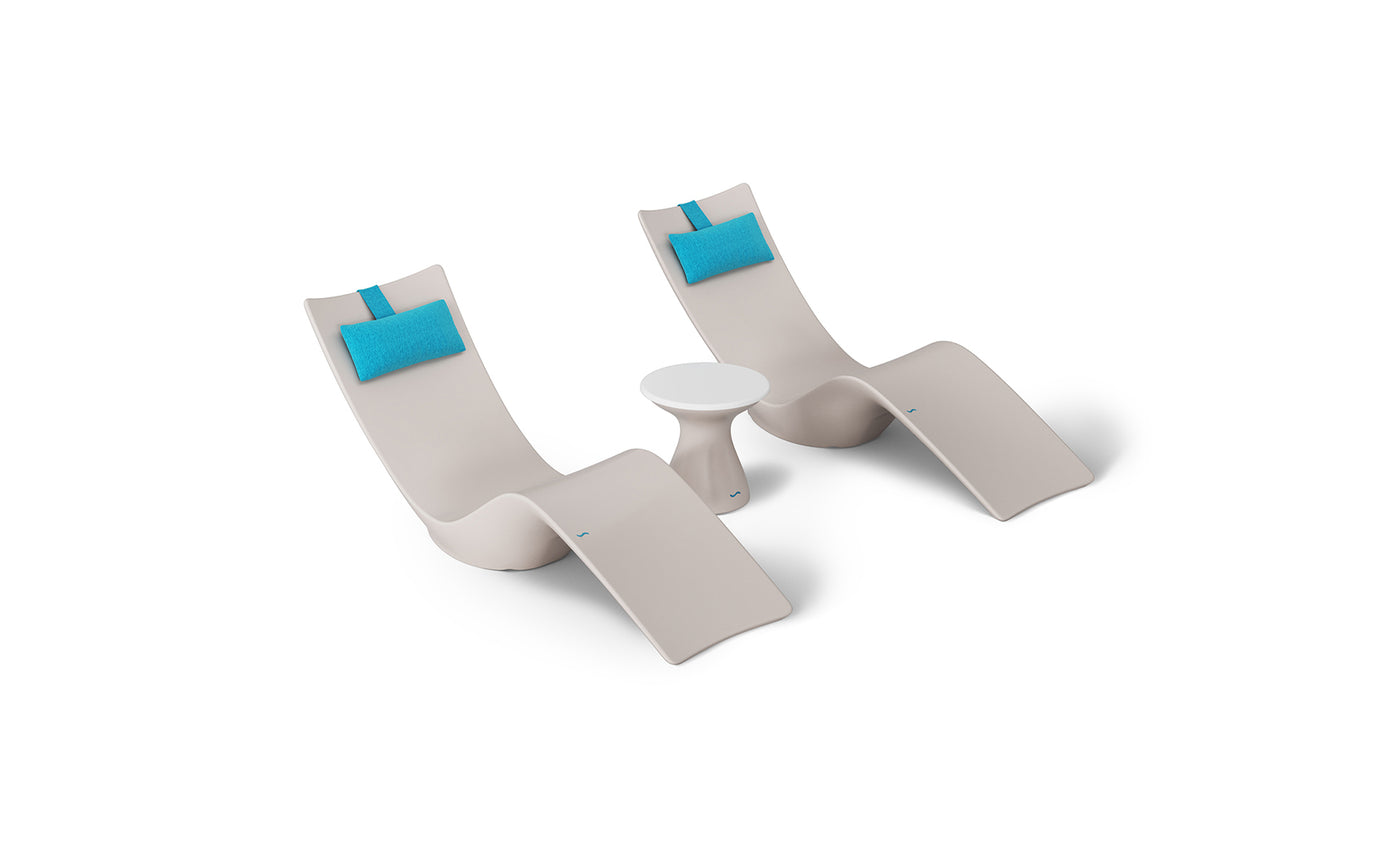 The Resort Luxury Outdoor Paradise In-Pool Furniture Bundle by Ledge Lounger features two modern beige lounge chairs with turquoise headrests and a small round white table, perfect for elegant relaxation poolside against a plain white background.