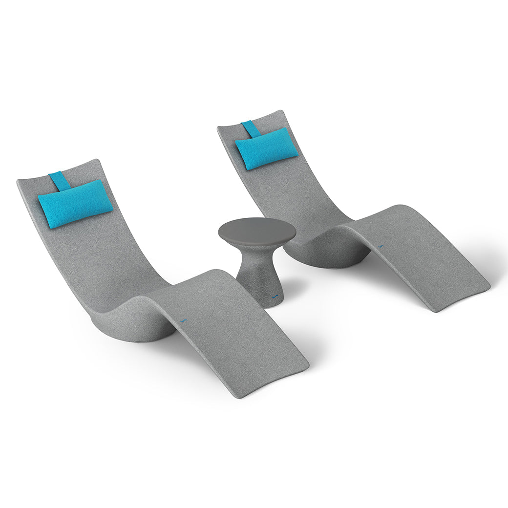 The Resort Luxury Outdoor Paradise In-Pool Furniture Bundle by Ledge Lounger includes two modern gray lounge chairs with curved designs and light blue head cushions, alongside a small round table. Ideal for poolside relaxation, the set contrasts elegantly against a crisp white background.