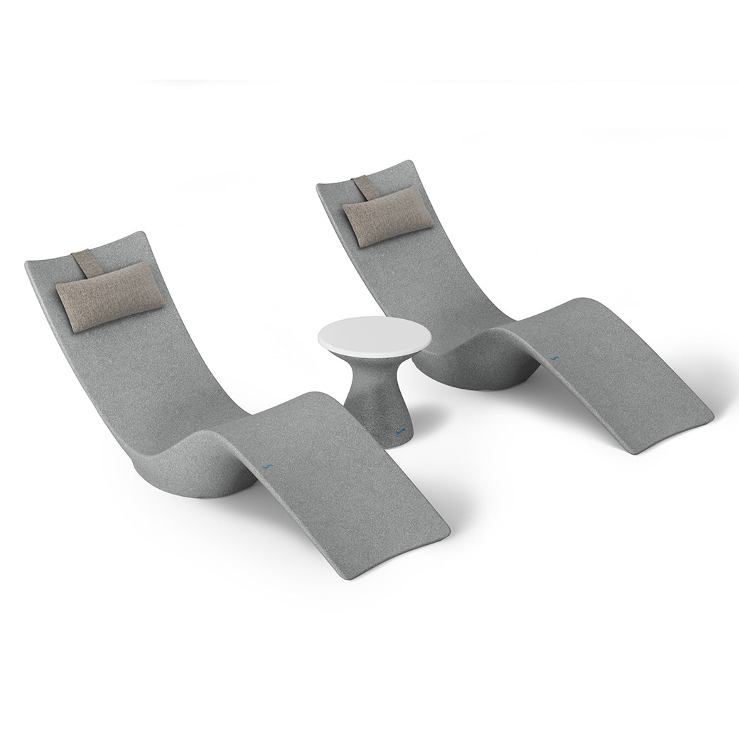 The Resort Luxury Outdoor Paradise In-Pool Furniture Bundle by Ledge Lounger features two modern gray chaise lounge chairs with brown cushions, ideal for poolside relaxation. They face each other with a small round white table between them, set against a white background.