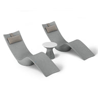 The Resort Luxury Outdoor Paradise In-Pool Furniture Bundle by Ledge Lounger features two modern gray chaise lounge chairs with brown cushions, ideal for poolside relaxation. They face each other with a small round white table between them, set against a white background.