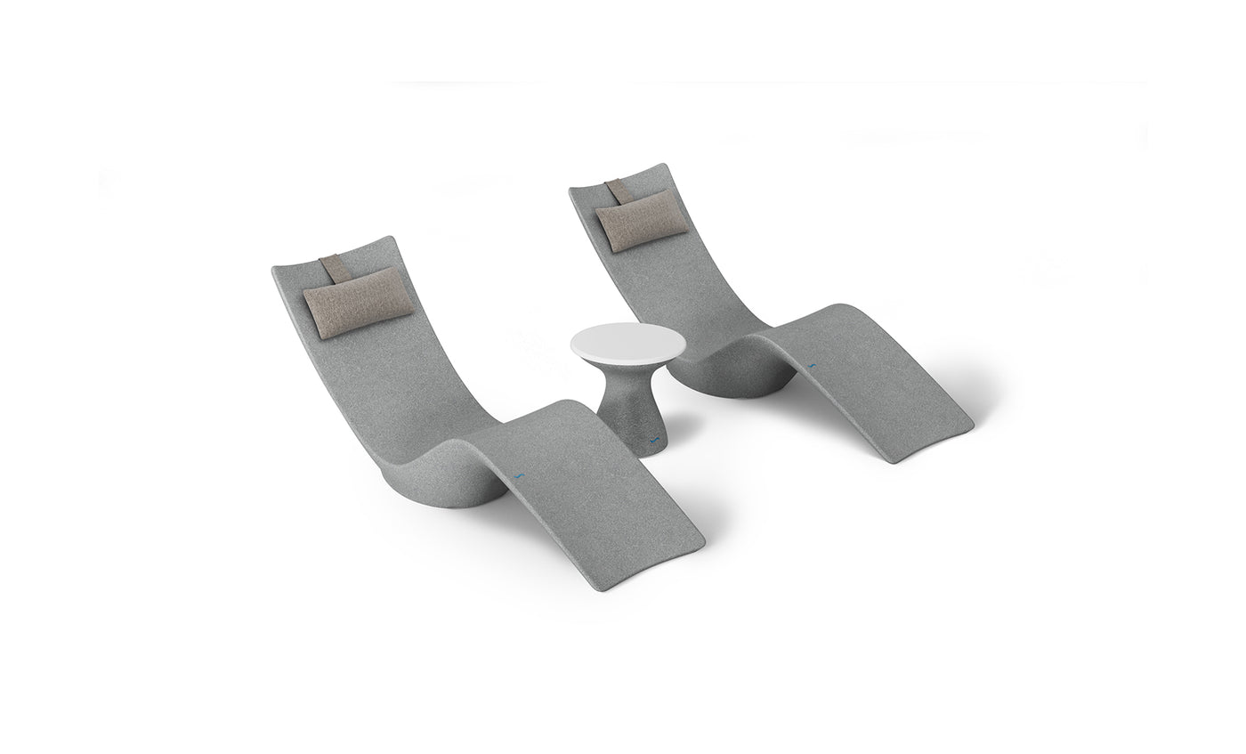 The Resort Luxury Outdoor Paradise In-Pool Furniture Bundle by Ledge Lounger features two modern gray chaise lounge chairs with brown cushions, ideal for poolside relaxation. They face each other with a small round white table between them, set against a white background.
