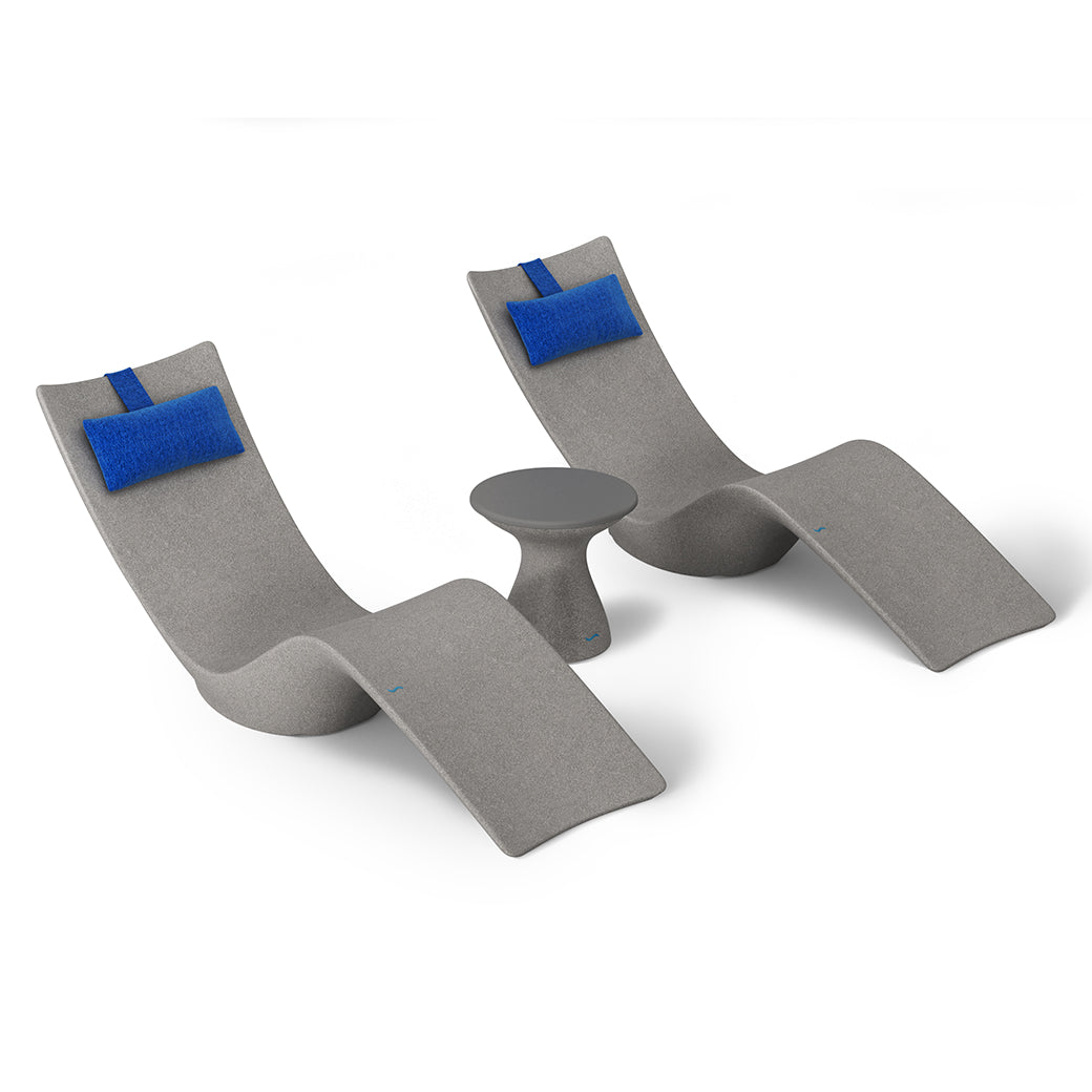 The Ledge Loungers Resort Luxury Outdoor Paradise In-Pool Furniture Bundle features two modern gray lounge chairs with blue head cushions facing each other, divided by a small round gray table. Perfect for poolside relaxation, this elegant ensemble sits on a white backdrop, offering serene escape.