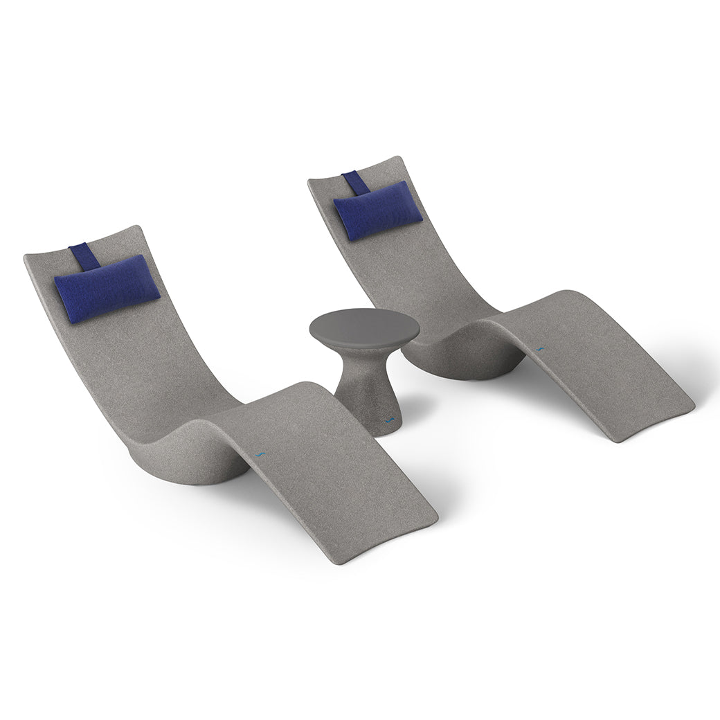 The Resort Luxury Outdoor Paradise In-Pool Furniture Bundle by Ledge Lounger includes two modern gray chaise loungers with blue headrests, paired with a small round gray side table, all designed for sleek poolside relaxation.