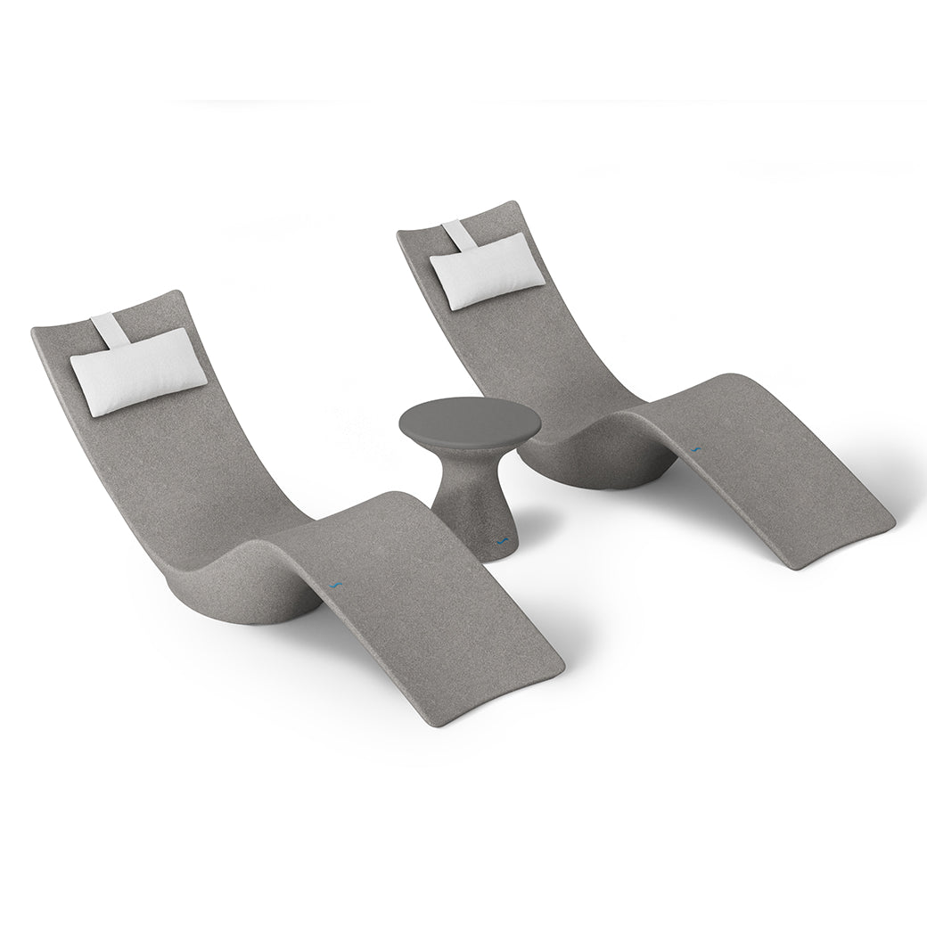 The Resort Luxury Outdoor Paradise In-Pool Furniture Bundle by Ledge Lounger includes two modern gray reclining chaise loungers with white headrest cushions and a small matching gray side table, ideal for poolside relaxation, all set against a plain white background.