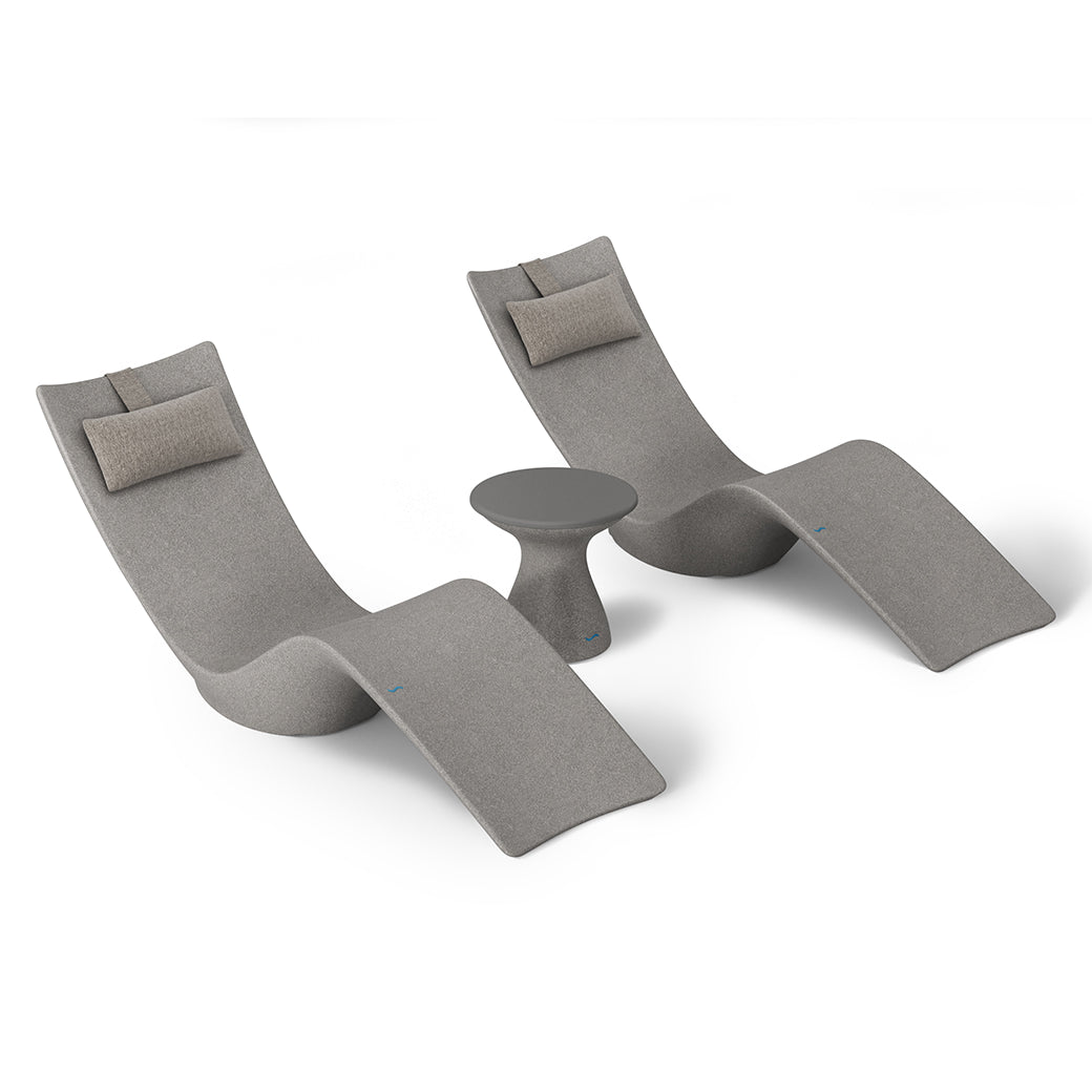 The Ledge Lounger Resort Luxury Outdoor Paradise In-Pool Furniture Bundle includes two modern grey chaise loungers with beige cushions, set around a small round table. Perfect for poolside relaxation, this chic set stands out against a white backdrop, showcasing its sleek design.