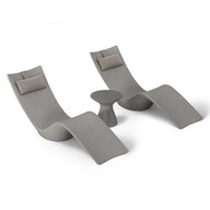The Ledge Lounger Resort Luxury Outdoor Paradise In-Pool Furniture Bundle includes two modern grey chaise loungers with beige cushions, set around a small round table. Perfect for poolside relaxation, this chic set stands out against a white backdrop, showcasing its sleek design.