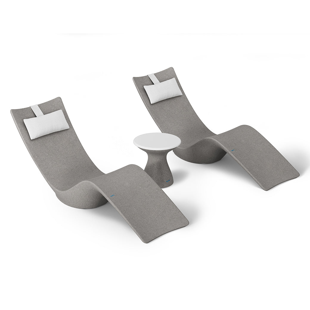 The Resort Luxury Outdoor Paradise In-Pool Furniture Bundle by Ledge Lounger features two sleek, modern gray lounge chairs with white cushions flanking a small round table. Perfect for poolside relaxation, their wavy design ensures comfort and style against a plain white background.