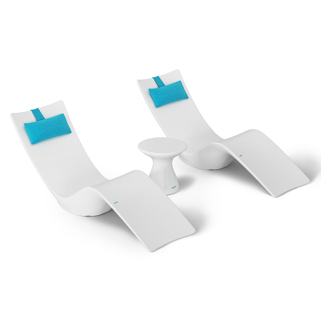 The Ledge Lounger Resort Luxury Outdoor Paradise In-Pool Furniture Bundle includes two sleek, modern white chaise loungers with turquoise headrests and a small round white side table, perfect for poolside relaxation against a pristine white backdrop.